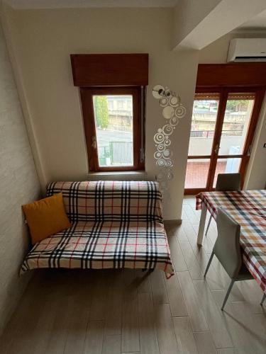 スカレアにあるApartment in Scaleaのベンチ、テーブル、窓が備わる客室です。