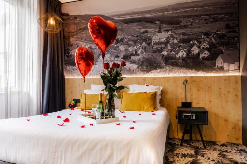 a bedroom with red hearts and flowers on a bed at L' Hôtel & Spa Ribeauville- Haut-Koenigsbourg in Ribeauvillé