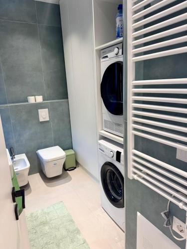 a bathroom with a washing machine and a toilet at Pearl Pool Luxury Villa in Golem