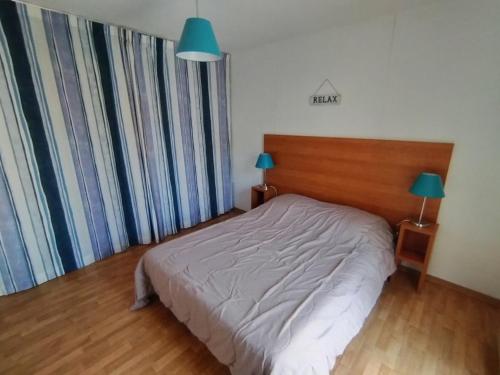 - une chambre avec un lit et 2 lampes et rideaux dans l'établissement Appartement avec piscine, tennis et terrasse à Soustons – Idéal famille - FR-1-379-164, à Soustons