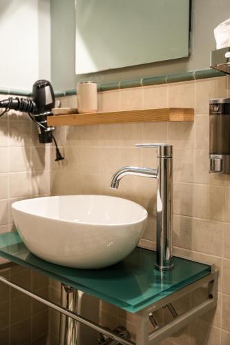 a white sink on a glass counter in a bathroom at L' ΛᄂᄂӨGGIӨ di KΛMΛ' in Cesena