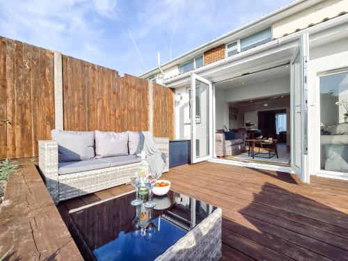 eine Terrasse mit einer Couch und einem Tisch in der Unterkunft Luxury Sea View Retreat with Hot Tub Sleeps 8 in Dover