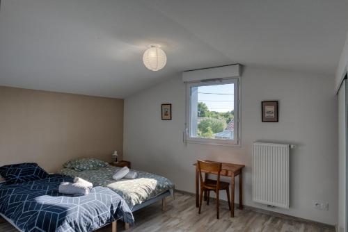 une chambre avec un lit, une table et une fenêtre dans l'établissement Agréable duplex avec jardin et terrasse, à La Teste-de-Buch