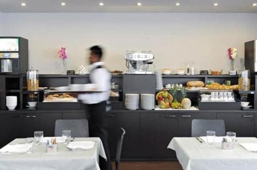 a man standing in front of a buffet in a restaurant at M14 Hotel & Spa in Padova