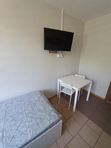 a bedroom with a bed and a table and a tv at Kwatery pracownicze in Łódź