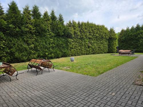 a patio with two benches and a grass field at Kwatery pracownicze in Łódź