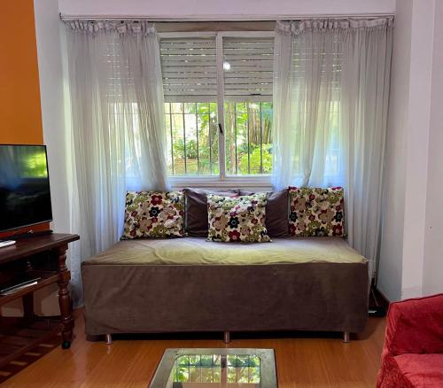a couch in a living room with a window at Administracion Callao in Buenos Aires
