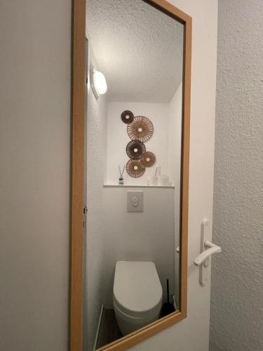 une salle de bain avec toilettes et miroir dans l'établissement Studio villa proche village natu, au Cap d'Agde