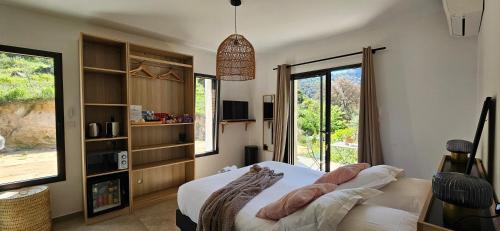 a bedroom with a bed and a large window at Hôtel Résidence de standing Casa Pian d'Olmo in Olmiccia