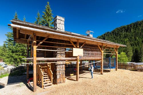 a wooden building with a person standing in front of it at Caravan Park Sexten in Sesto
