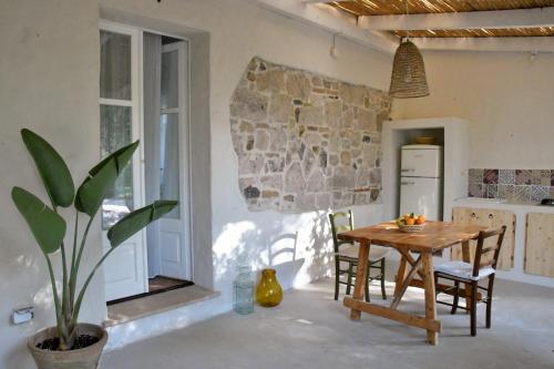 a kitchen and dining room with a wooden table and chairs at Giallo Limone in Teulada
