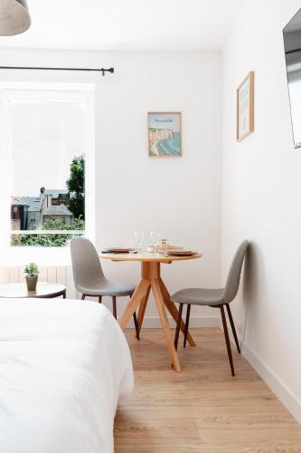 une salle à manger avec une table et des chaises en bois dans l'établissement Washington 2, au Havre