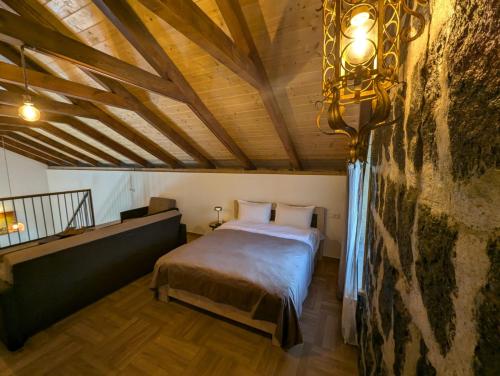 KʼaghsiにあるRiverHome Villaのベッドと石の壁のある寝室