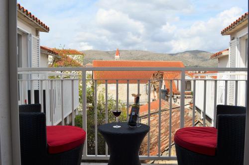 a balcony with a bottle of wine and a glass at Apartments Gea Trogir in Trogir
