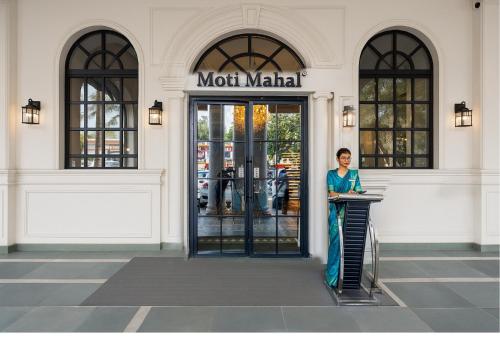 a woman standing in front of a front door of a store at Saltstayz Autograph - Connaught Place in New Delhi