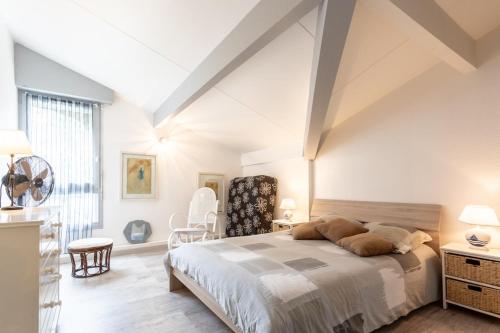 une chambre avec un grand lit et une chaise dans l'établissement Maison proche du lac !, à Biscarrosse