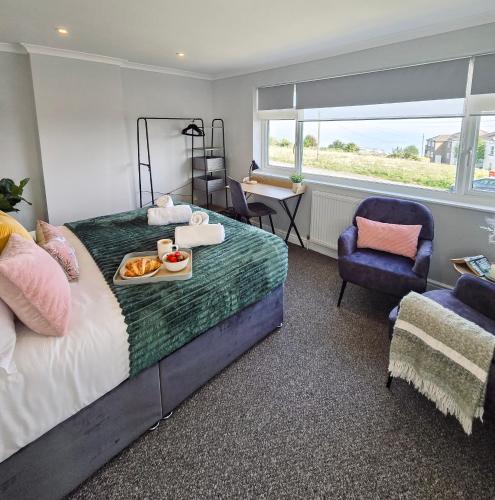 a bedroom with a bed with a tray of food on it at Luxury Sea View Retreat with Hot Tub Sleeps 8 in Dover