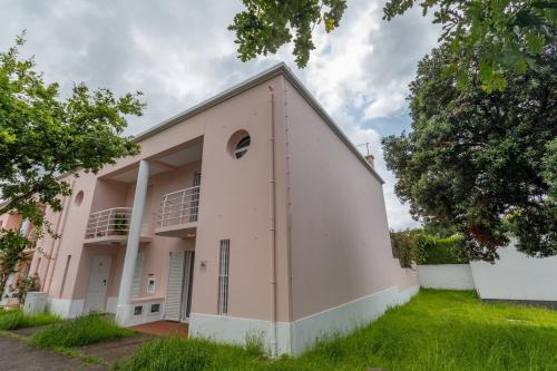 a large pink building with a tree in front of it at GuestReady - Monaco Nest in Ponta Delgada
