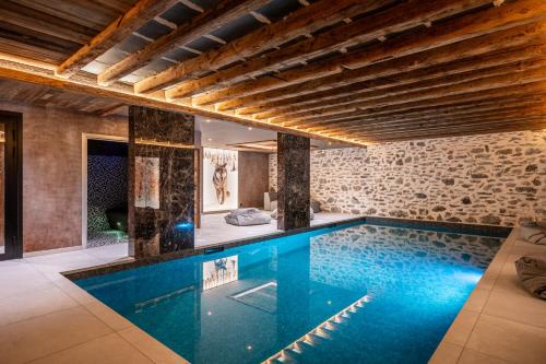 - une piscine dans une maison dotée d'un mur en pierre dans l'établissement Chalet Gaston, à Champagny-en-Vanoise