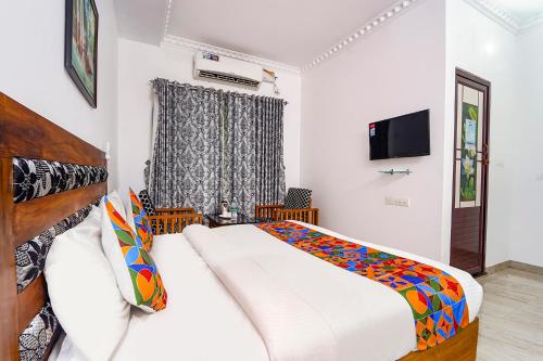 a bedroom with a large bed and a television at Fabhotel Star Inn Plus - Nr Kovalam Beach in Kovalam