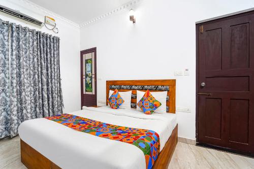 a bedroom with a bed and a window and a door at Fabhotel Star Inn Plus - Nr Kovalam Beach in Kovalam
