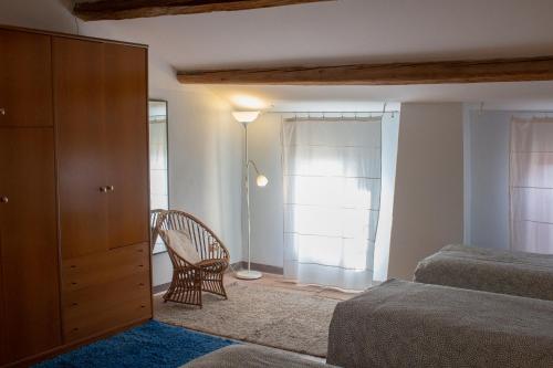 a bedroom with a bed and a chair and a dresser at Agriturismo Valpagliaro in Formignana