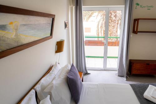 a bedroom with a bed with a painting on the wall at kasa Tambla in Ponta do Sol
