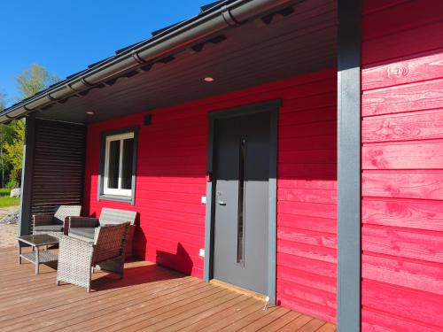 a red house with chairs on a deck at Family vacation, 2 bedroom house - Red House in Lõupõllu