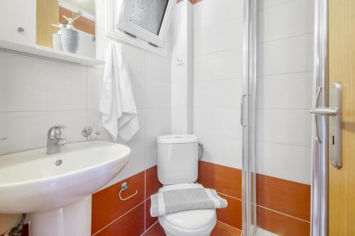 a bathroom with a toilet and a sink and a shower at Panorama studios 3 in Póndi