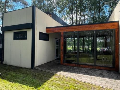 a house with a large glass door in a yard at Unterkünfte bei Wake and Beach am Halbendorfer See in Schleife