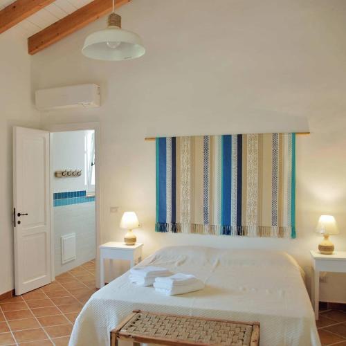 a bedroom with a bed with two tables and two lamps at Giallo Limone in Teulada