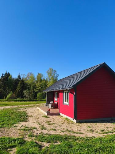 a red shed with a black roof in a field at Family vacation, 2 bedroom house - Red House in Lõupõllu