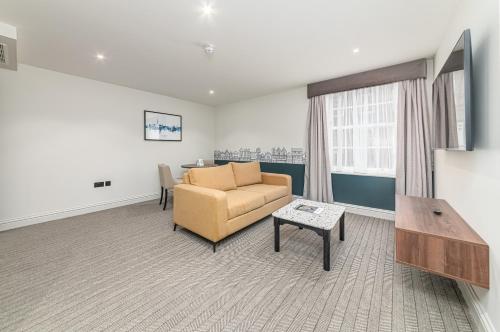 a living room with a couch and a table at Mercure Salisbury White Hart Hotel & Apartments in Salisbury