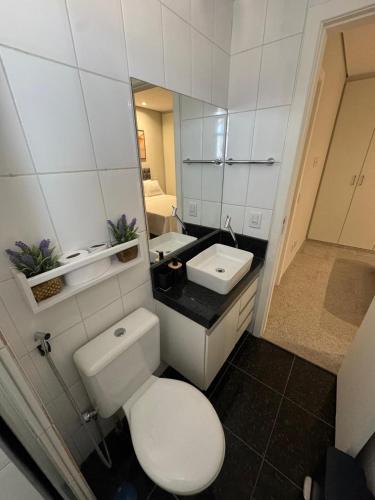 a bathroom with a white toilet and a sink at Raja Vista da Serra in Belo Horizonte