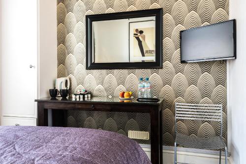 a bedroom with a picture on a wall with a mirror at Paskins Town House in Brighton & Hove