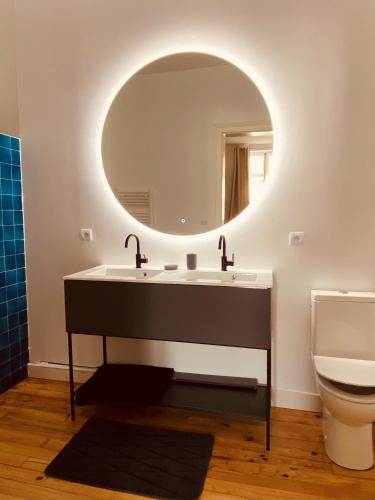 une salle de bain avec un lavabo et un miroir dans l'établissement Maison de charme avec piscine, à Dax