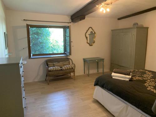 a bedroom with a bed and a chair and a window at Beautiful Big Home with Swimming Pool and Nature Grounds in Auterrive