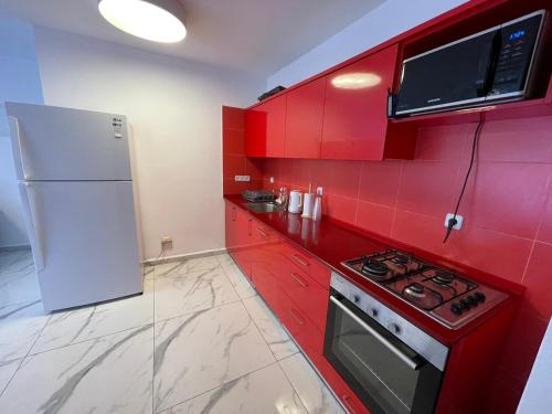 a red kitchen with a stove and a refrigerator at 4 חדרים מרווחת 138 מ"ר חניה חינם קרוב לים in Eilat