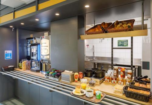 a kitchen with a counter with bread and food at B&B HOTEL Moulins in Toulon-sur-Allier