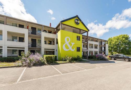 a building with a sign in front of a parking lot at B&B HOTEL Moulins in Toulon-sur-Allier