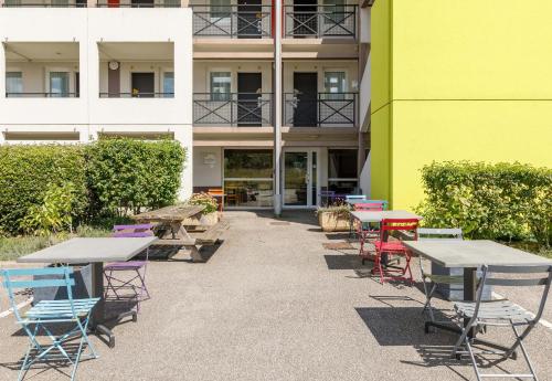 a group of tables and chairs in front of a building at B&B HOTEL Moulins in Toulon-sur-Allier