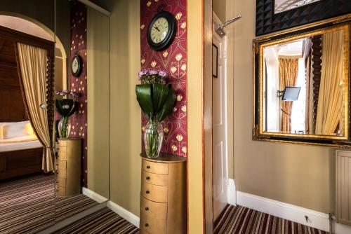 a vase of flowers on a dresser in a room at Paskins Town House in Brighton & Hove