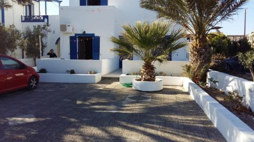 a parking lot with palm trees and a white building at Cycladic Relaxation Corner in Fira