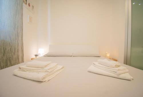 a white bedroom with white towels on a bed at Casa Bellavista in Torre Canne