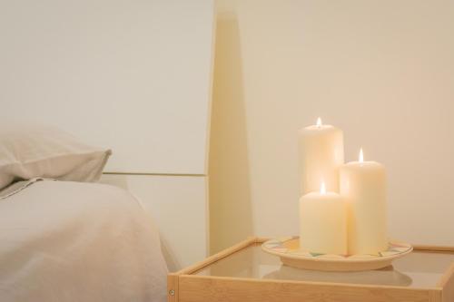 two candles sitting on a tray next to a bed at Casa Bellavista in Torre Canne