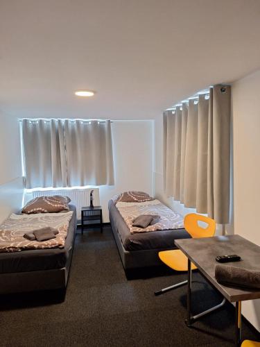 two beds in a room with a table and chairs at Hauptstr 10- 04603 Remsa in Windischleuba