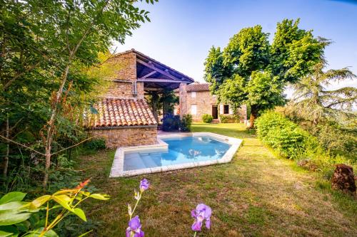 a garden with a swimming pool in front of a house at Clos Saint Michel - Piscine - Nature & Calme in Saint-Michel-de-Vax