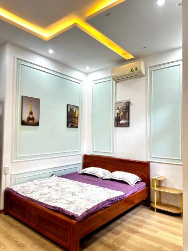 a bedroom with a bed in a room with windows at Tinahouse in Danang
