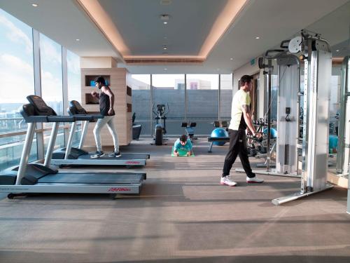 a man and a woman walking on a treadmill in a gym at Holiday Inn Chennai OMR IT Expressway by IHG in Chennai