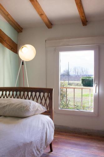 a bedroom with a bed and a large window at Agriturismo Valpagliaro in Formignana
